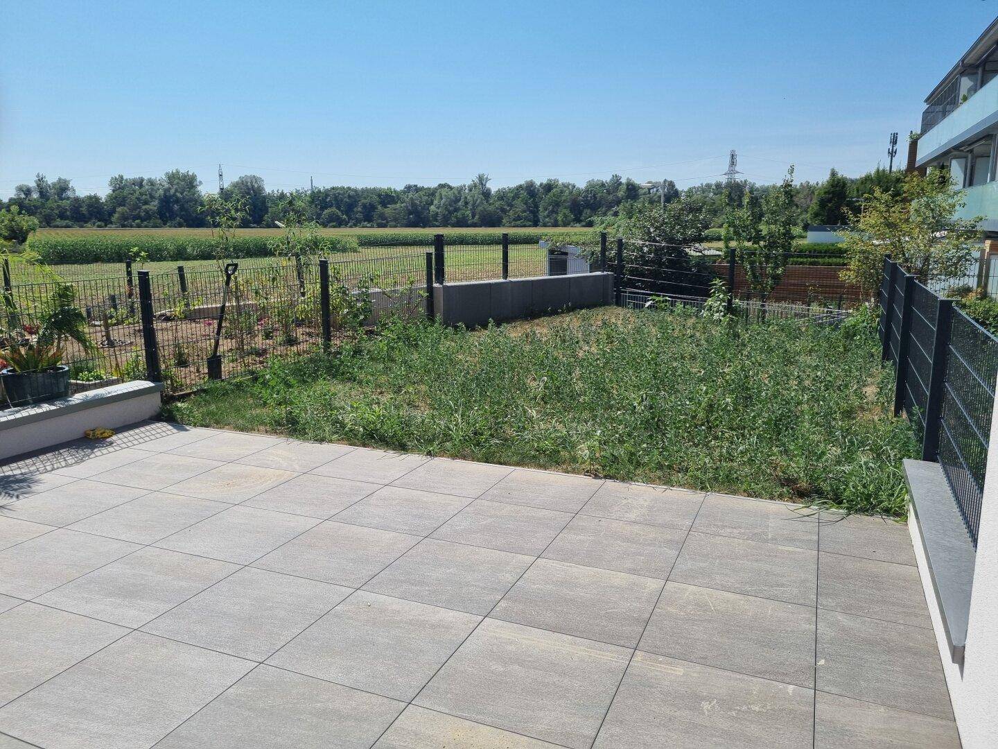 Private Terrasse mit angrenzendem Gartenbereich und Blick auf die umliegende Natur.