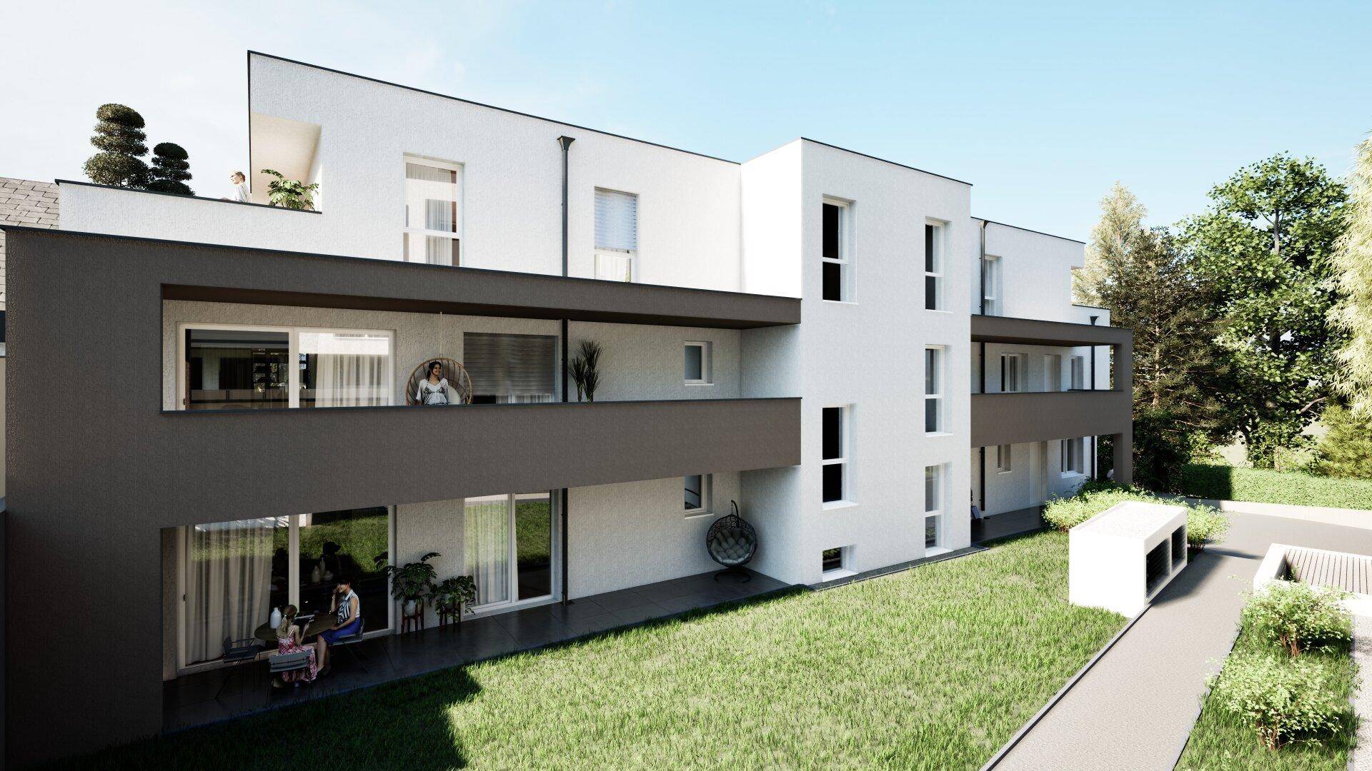 Rückseite des modernen Wohngebäudes mit gepflegter Rasenfläche und Terrassen im Erdgeschoss.