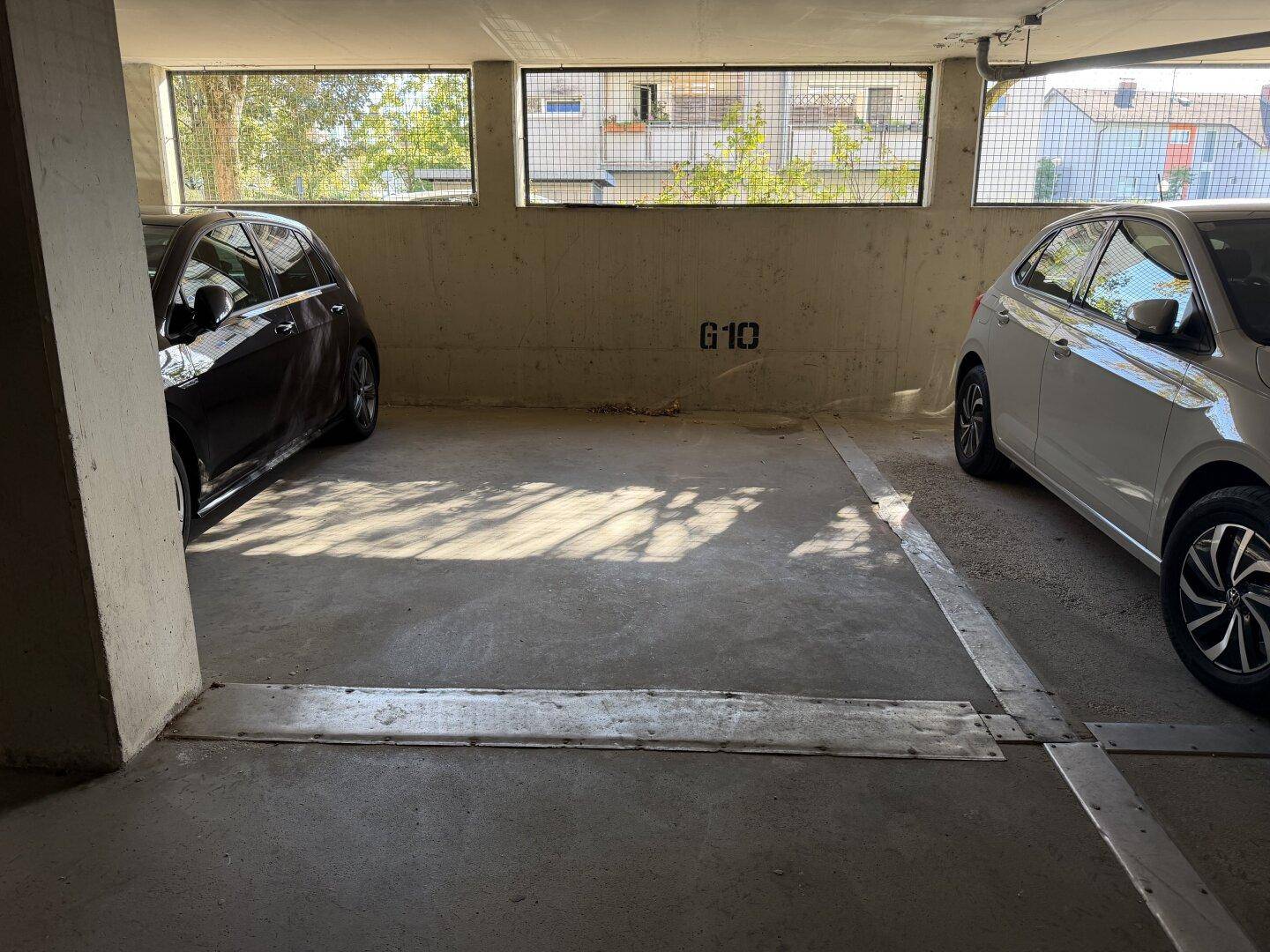 Tiefgarage mit zwei Stellplätzen und Betonwänden, gut beleuchtet.