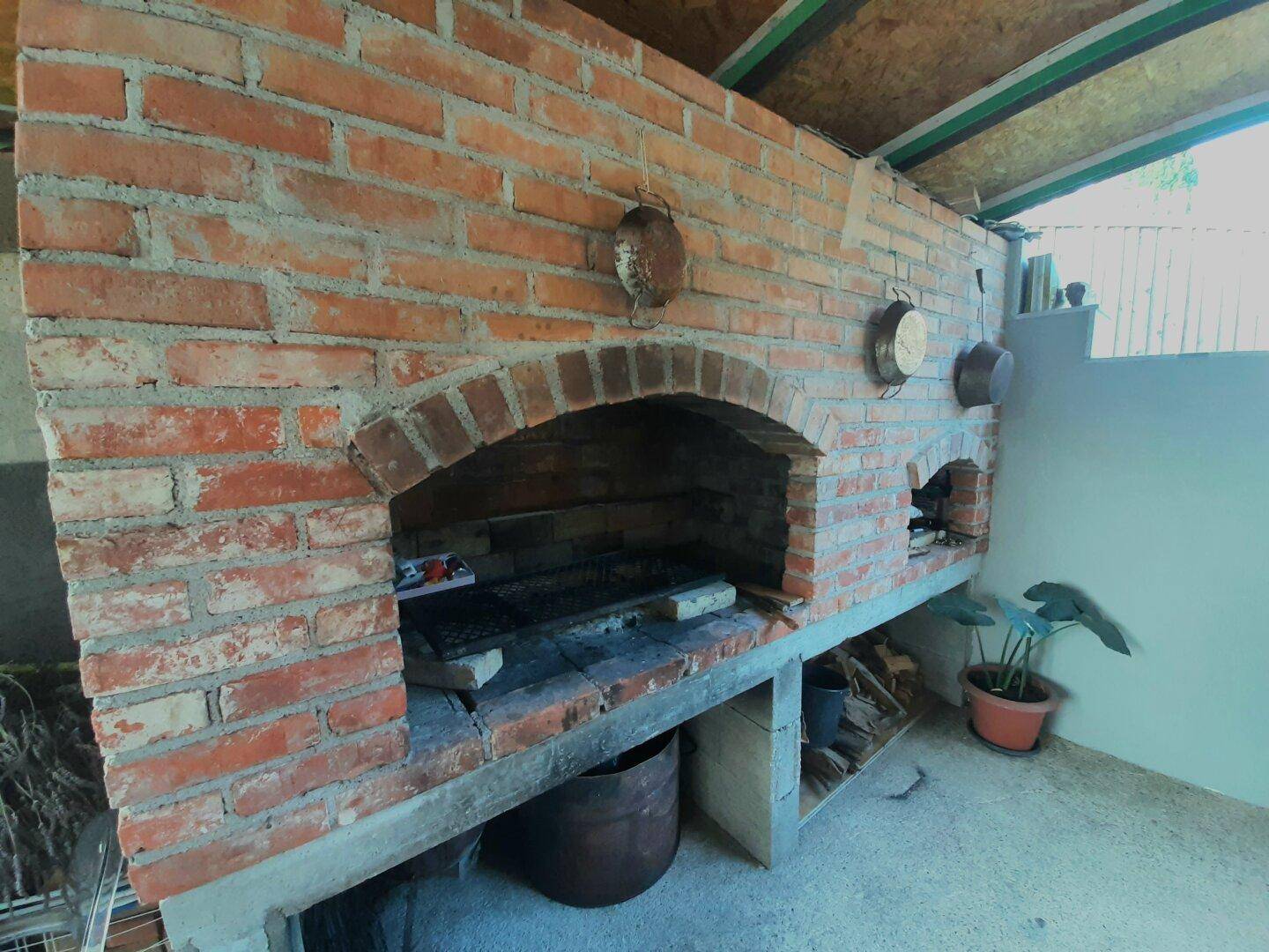 Rustikaler gemauerter Grillplatz im Freien, ideal für gesellige Abende.