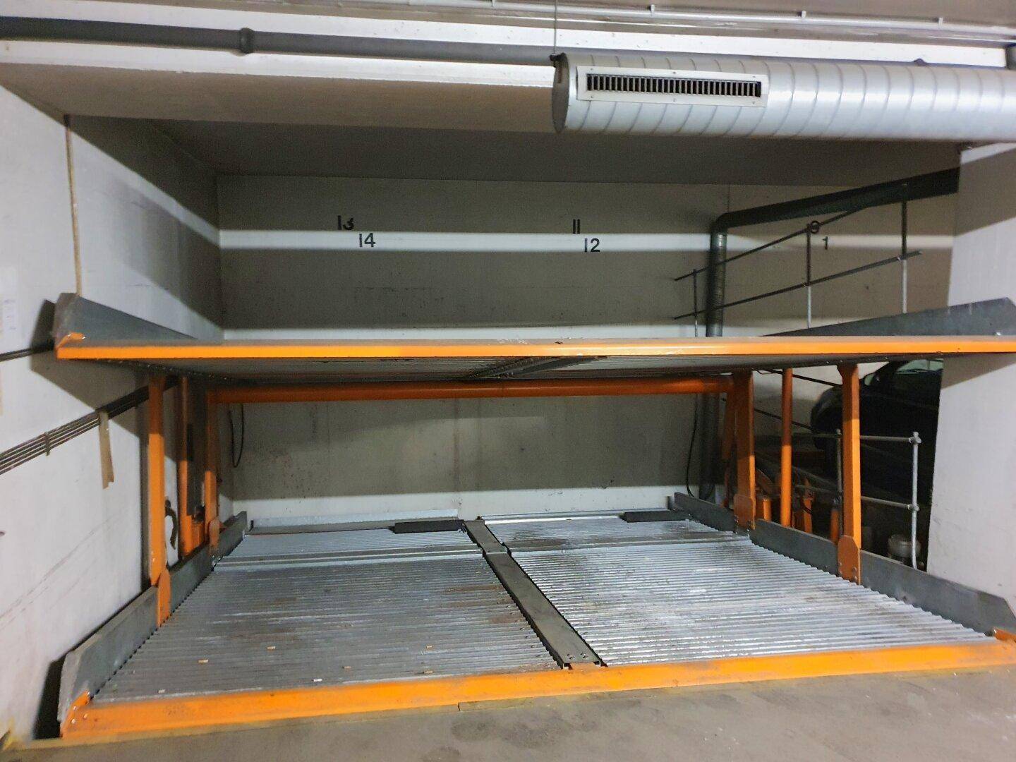 Detailansicht eines Doppelparkers in der Tiefgarage, der zwei Fahrzeuge übereinander aufnehmen kann.
