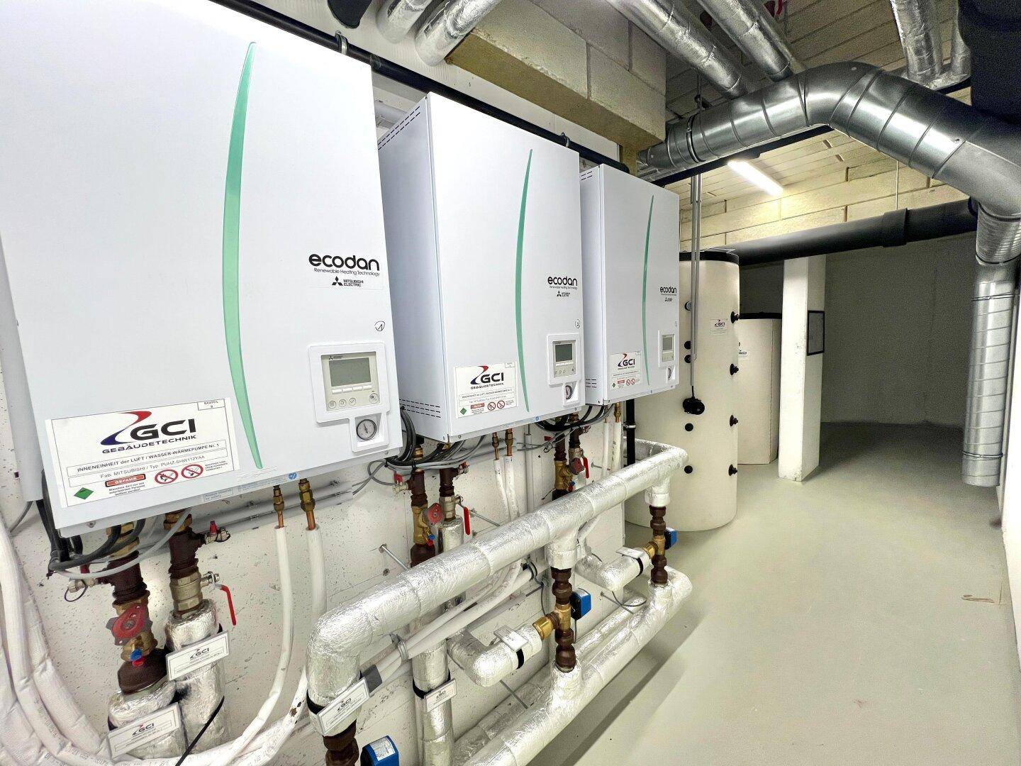Technikraum mit modernen Ecodan Wärmepumpen und umfangreicher Rohrinstallation.