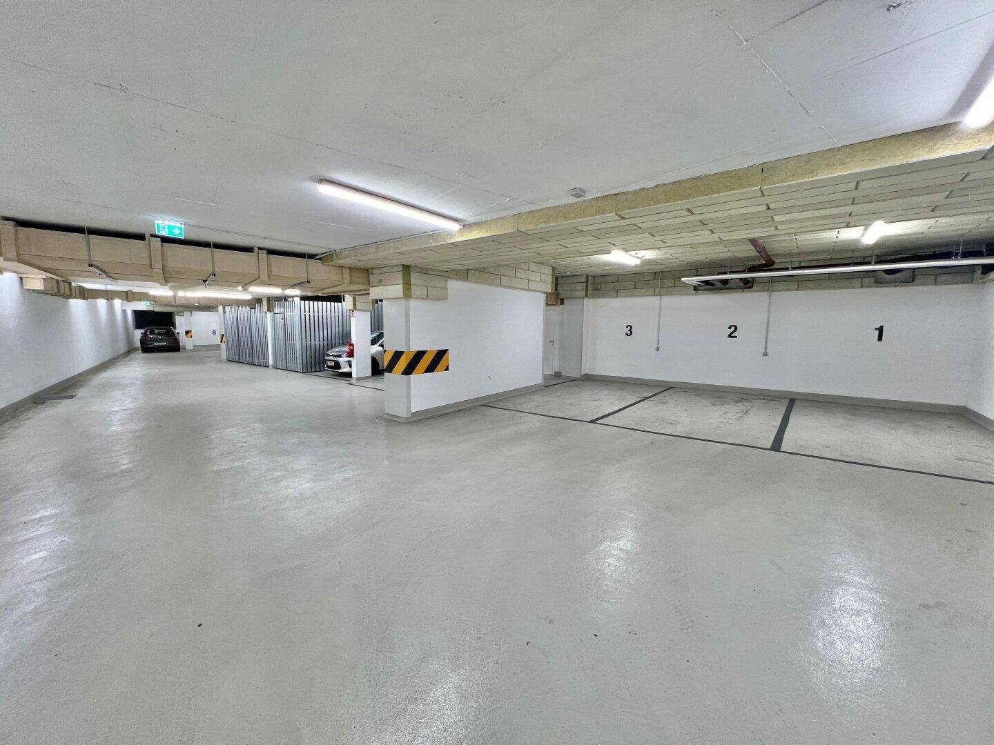 Geräumige Tiefgarage mit nummerierten Stellplätzen und guter Beleuchtung.