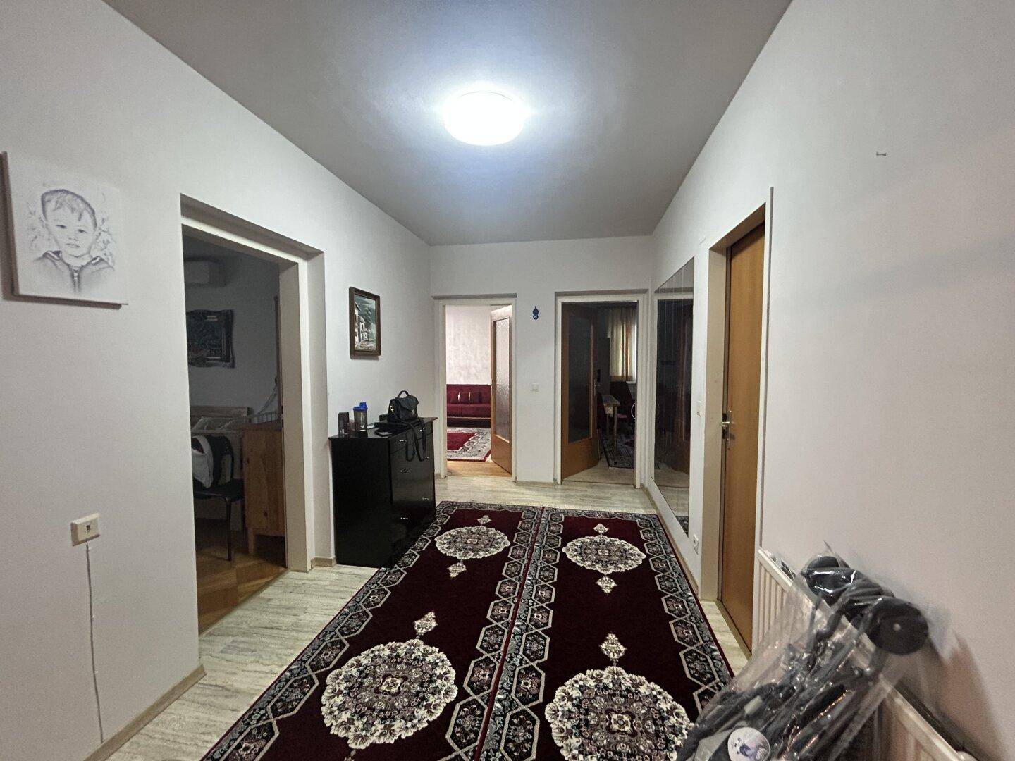 Heller Flur mit gemustertem Teppich und Zugang zu weiteren Räumen der Wohnung.