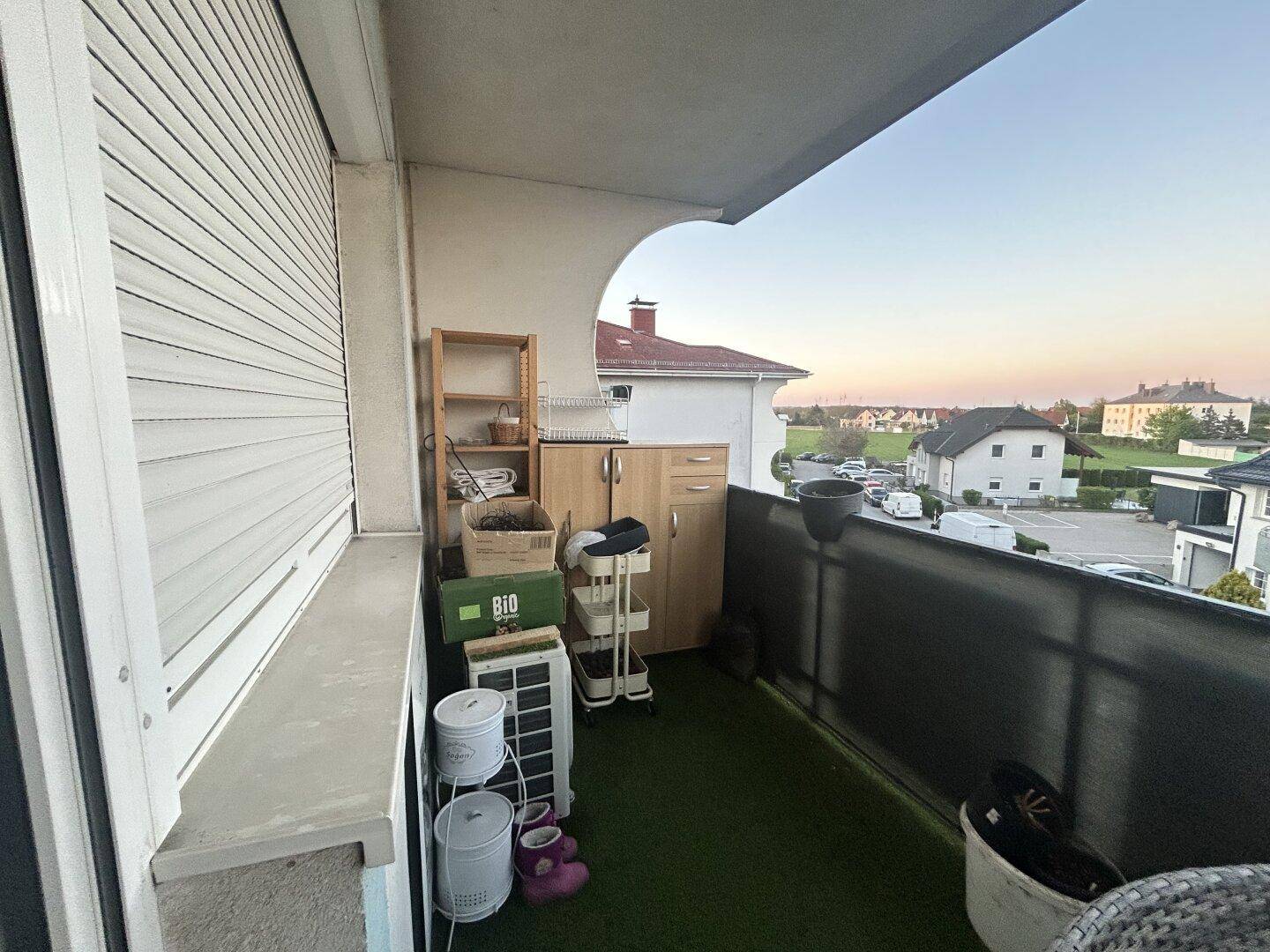 Balkon mit Kunstrasen, Stauraum und Blick auf die umliegende Wohngegend.