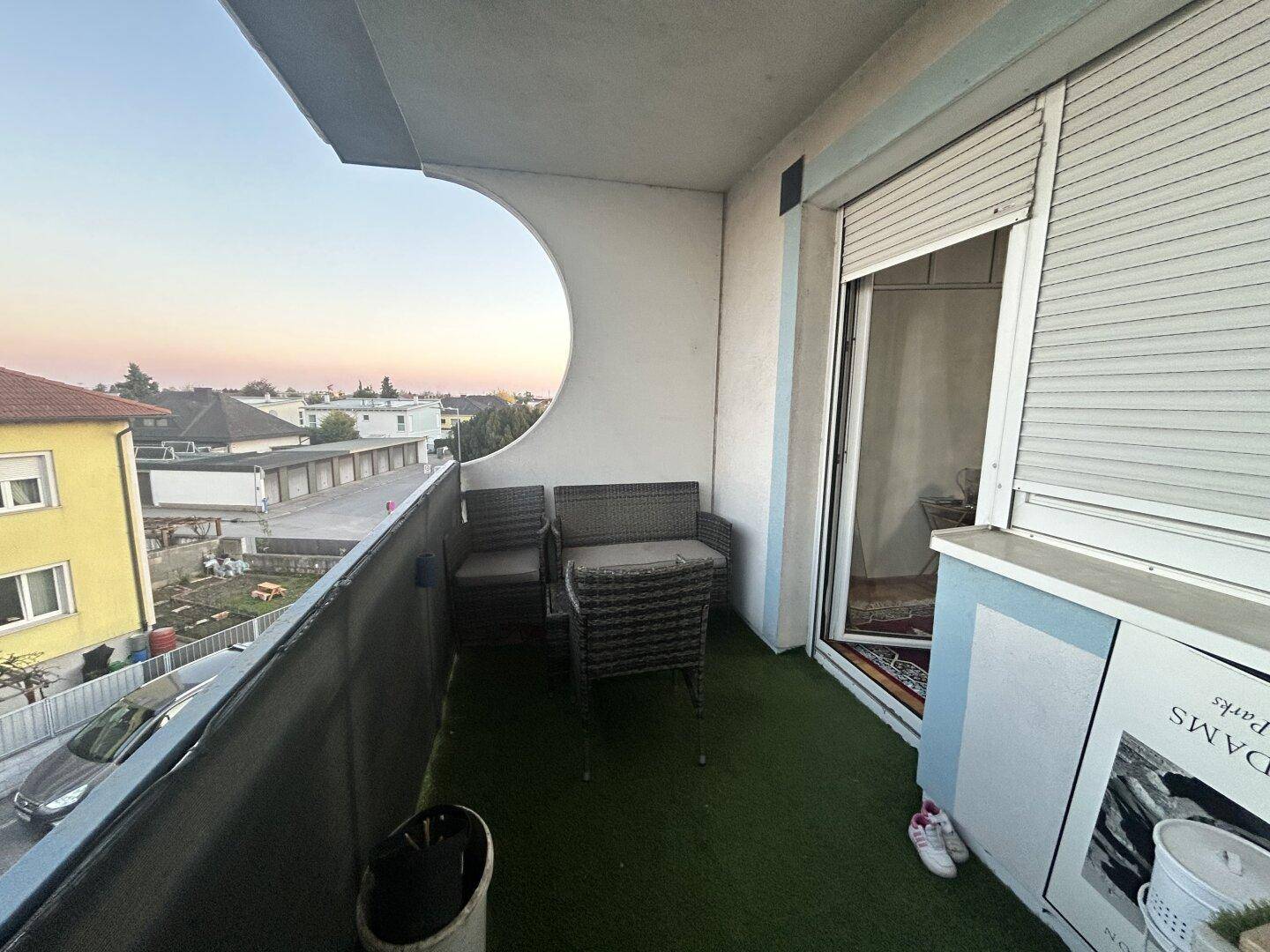 Gemütlicher Balkon mit Sitzgelegenheiten, Kunstrasen und weitem Blick über die Umgebung.