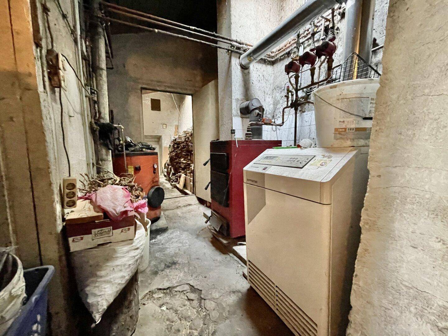 Heizungsraum im Keller mit Heizkessel und technischen Installationen, dient als Versorgungsbereich.
