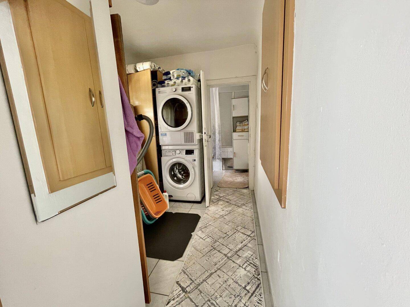Praktischer Hauswirtschaftsraum mit Waschmaschine und Trockner, bietet zusätzlichen Stauraum.