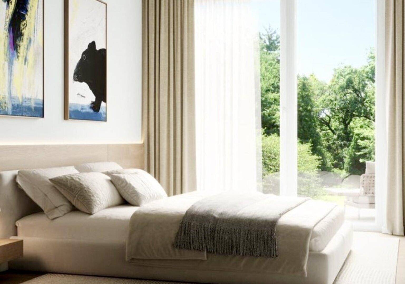 Helles Schlafzimmer mit großem Bett, Holzakzenten und Zugang zu einem Außenbereich.
