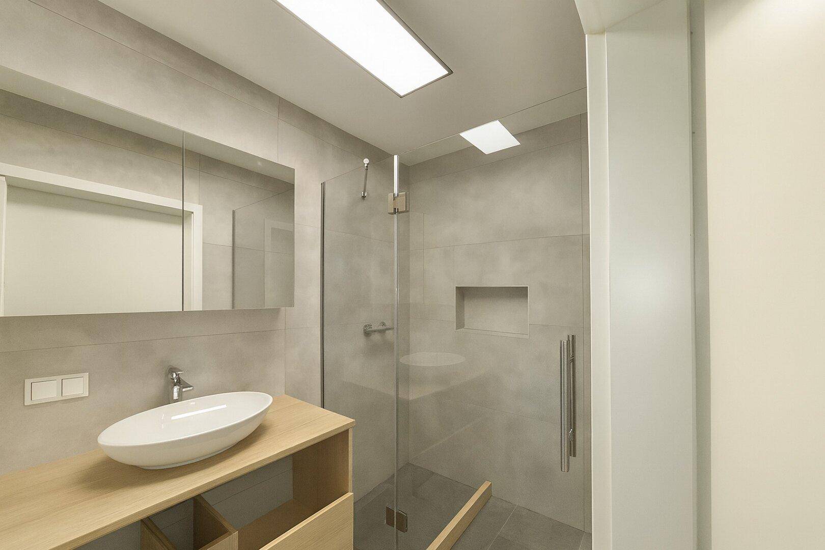 Modernes Badezimmer mit begehbarer Dusche, ovalem Waschbecken und Spiegelschrank.