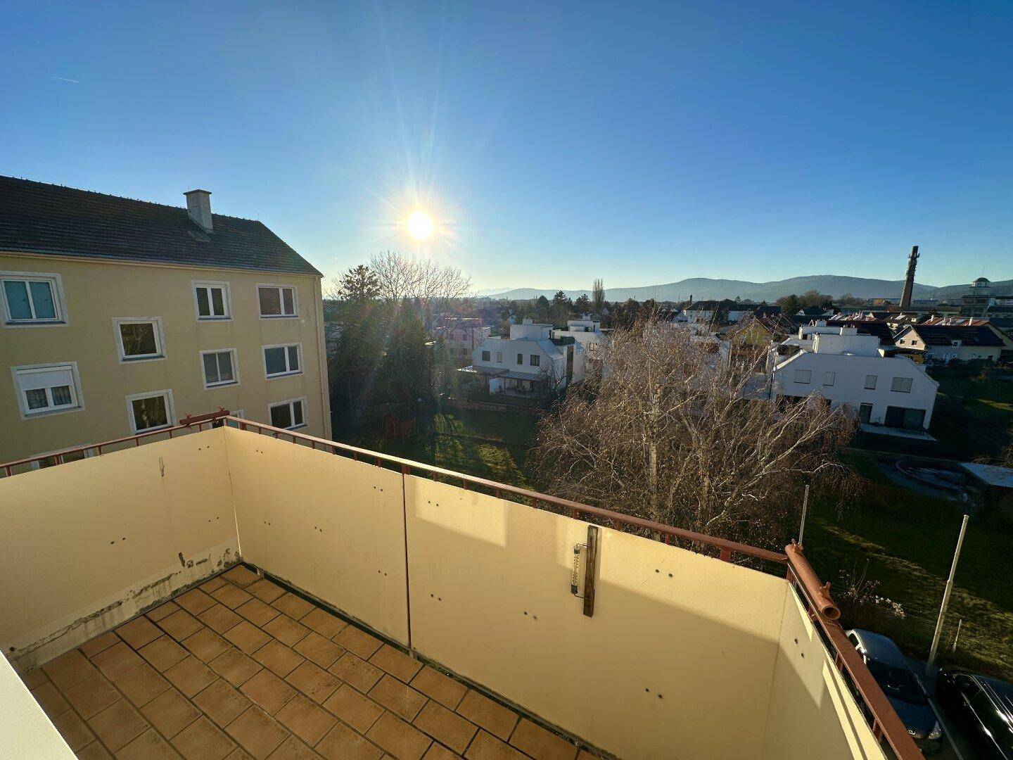 Sonniger Balkon mit weitem Blick über die Umgebung und die umliegende Landschaft.