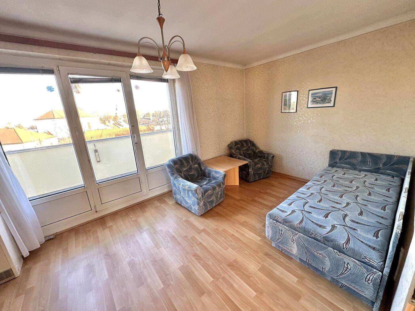 Heller Wohnbereich mit Schlafsofa, bequemen Sesseln und direktem Zugang zum Balkon.