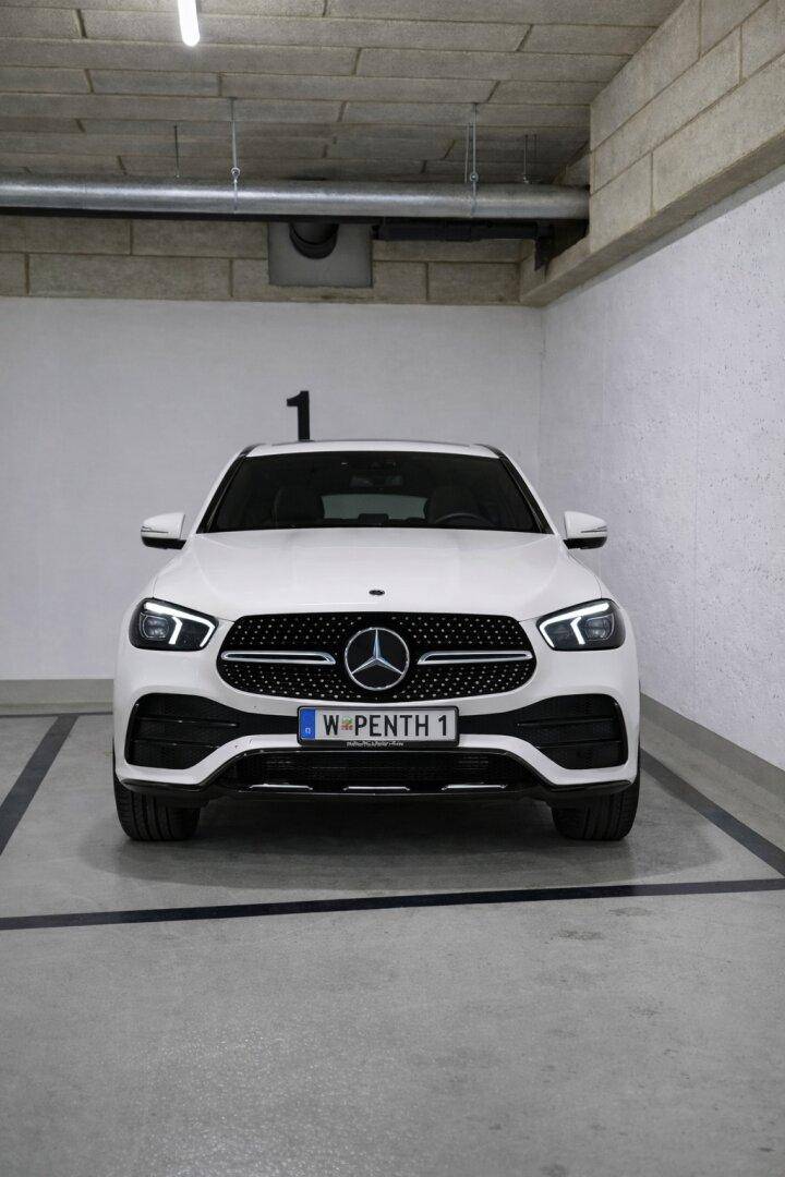 Einzelner Stellplatz in der Tiefgarage mit einem geparkten weißen Auto.