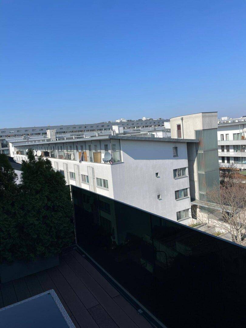 Weitblick über die Dächer der Stadt von einer oberen Etage aus, mit umliegenden Gebäuden.