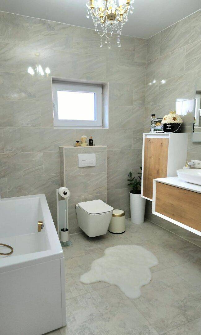 Helles Badezimmer mit Badewanne, wandhängendem WC und modernen Fliesen.