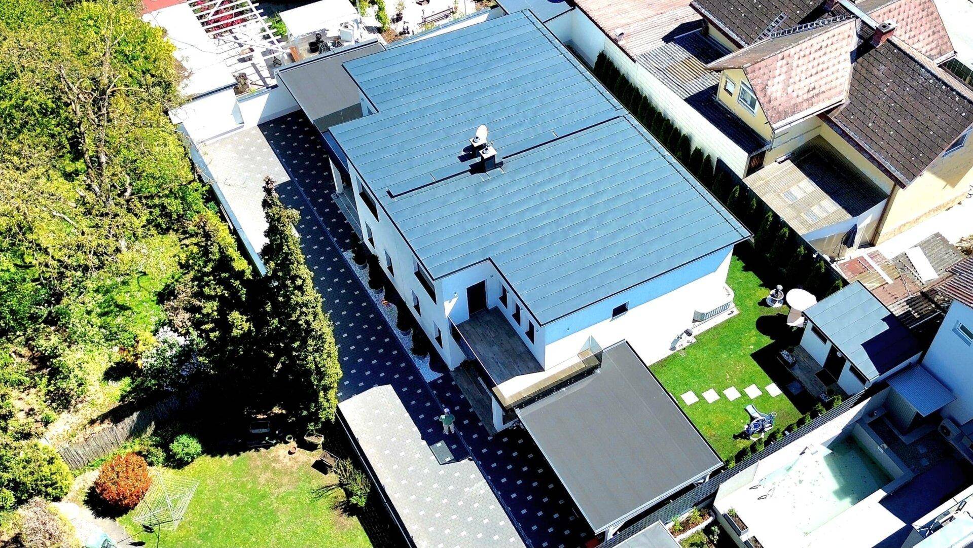 Moderne Wohnanlage mit Flachdach und gepflegtem Gartenbereich aus der Vogelperspektive.