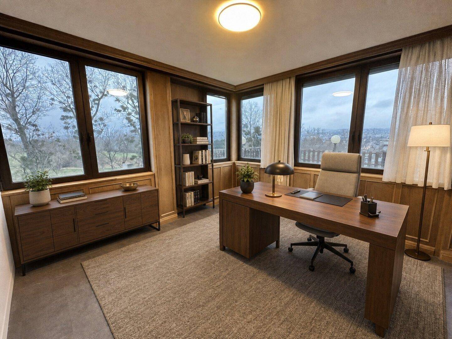Elegantes Heimbüro mit großem Holzschreibtisch, Bücherregal und weitem Blick ins Grüne durch die Fenster.