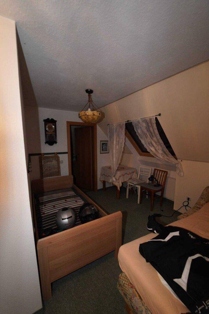 Gemütliches Schlafzimmer im Dachgeschoss mit schrägen Wänden und einem Einzelbett.