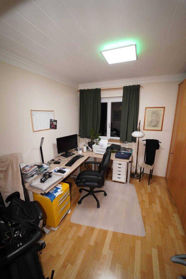 Ein funktionales Arbeitszimmer mit Holzboden, Schreibtisch und Stauraum, ideal für Home-Office.