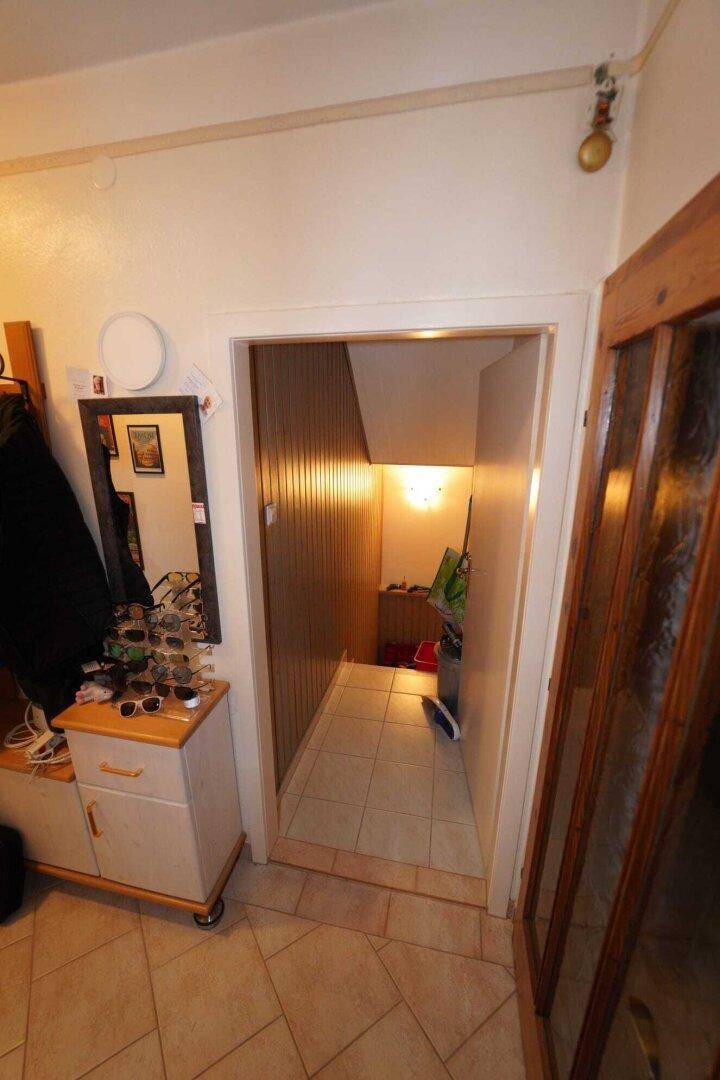 Flur mit Fliesenboden und Treppenabgang in den unteren Bereich des Hauses.