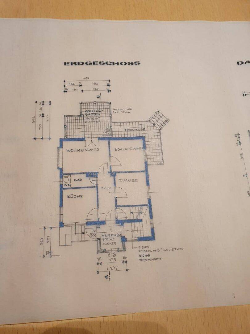 Grundriss des Erdgeschosses mit Wohnzimmer, Küche, Bad und Terrasse.