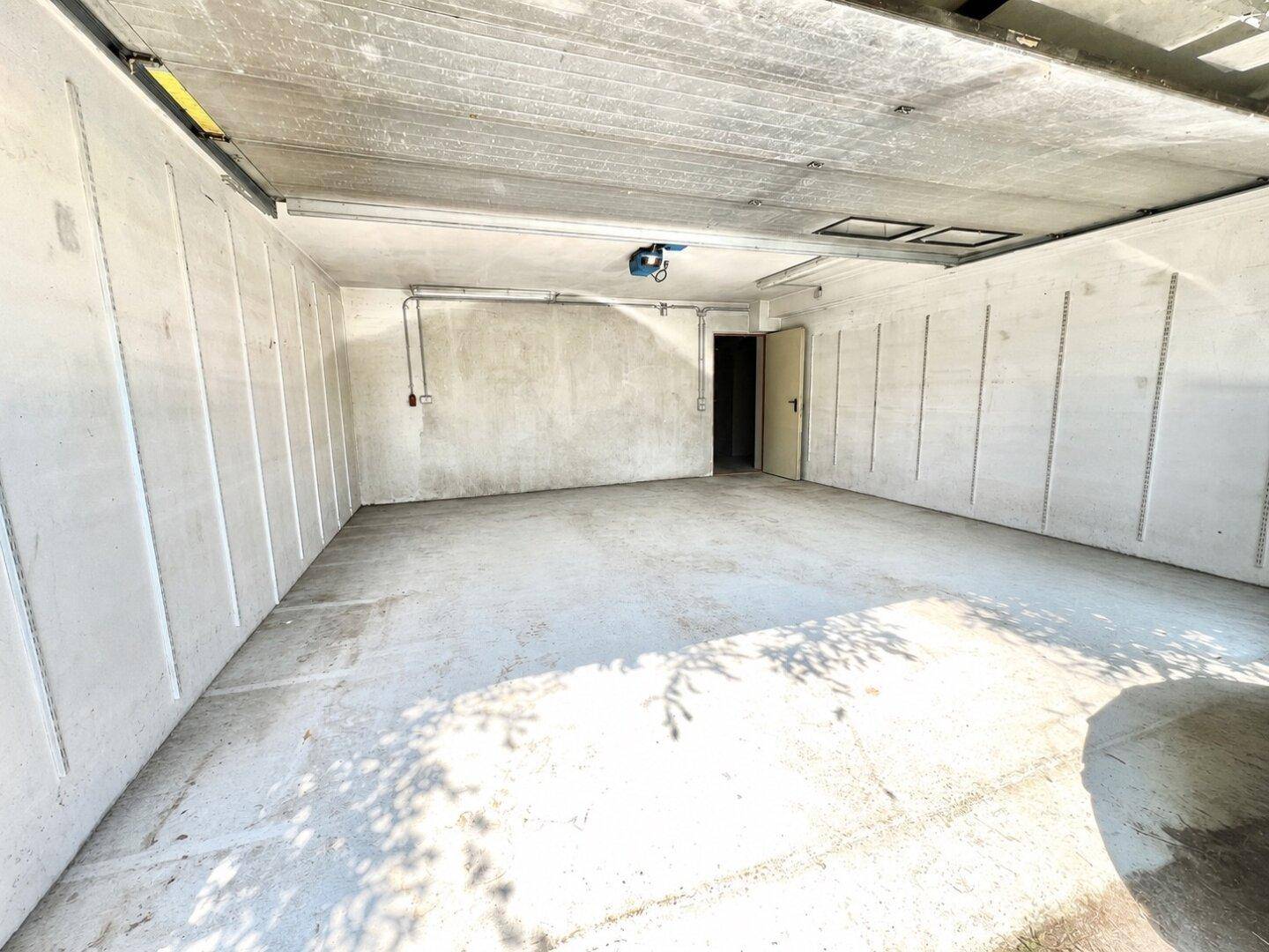Leere Garage mit Betonwänden und -boden, bereit zur Nutzung als Park- oder Lagerfläche.