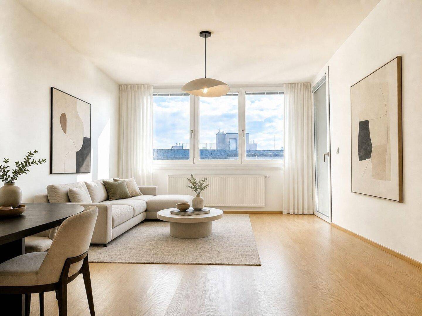 Helles Wohn-Esszimmer mit modernem Sofa, Esstisch und großen Fenstern.