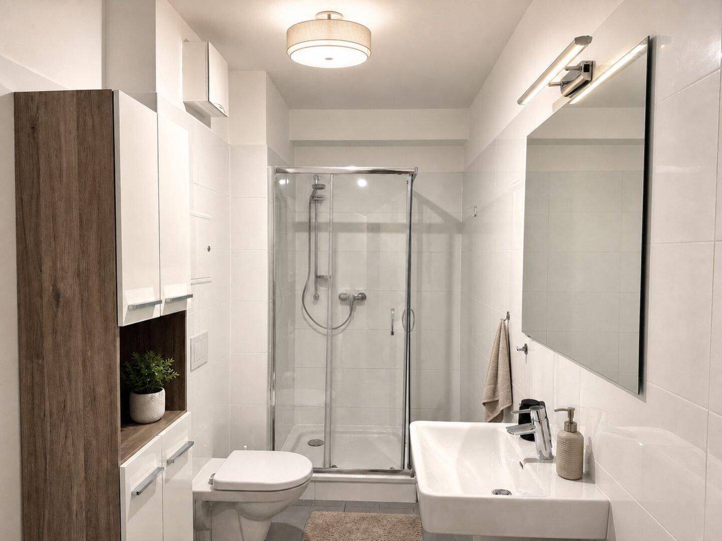 Modernes Badezimmer mit Duschkabine, wandhängendem WC und Einzelwaschbecken.