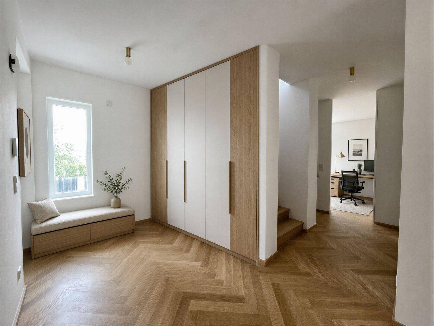 Geräumiger Flur mit Einbauschränken, Sitzbank und elegantem Fischgrätparkett.