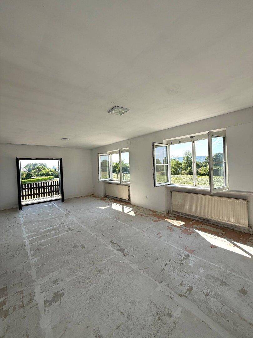 Großes, helles Zimmer mit Zugang zum Balkon und weitem Blick ins Grüne.