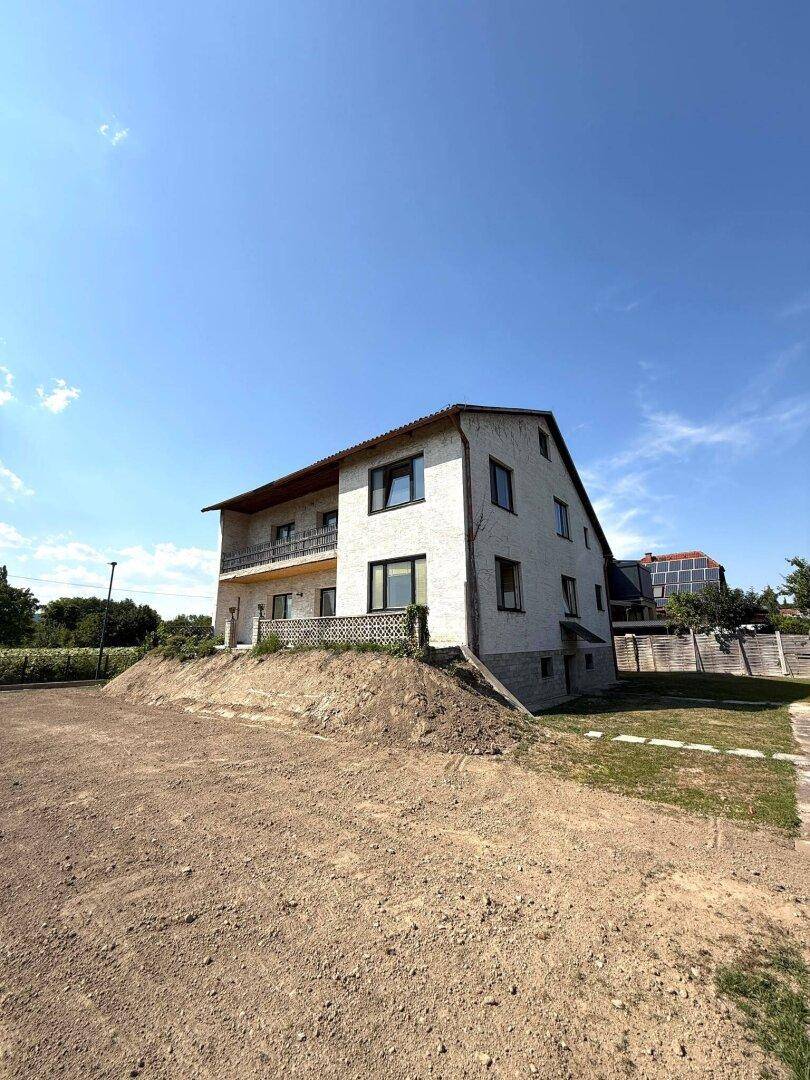Seitenansicht des Hauses auf einem erhöhten Grundstück mit weitem Blick.