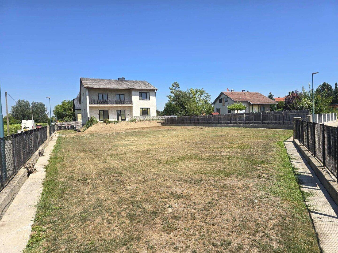 Weitläufiges Grundstück mit Rasenfläche und Blick auf das Einfamilienhaus.