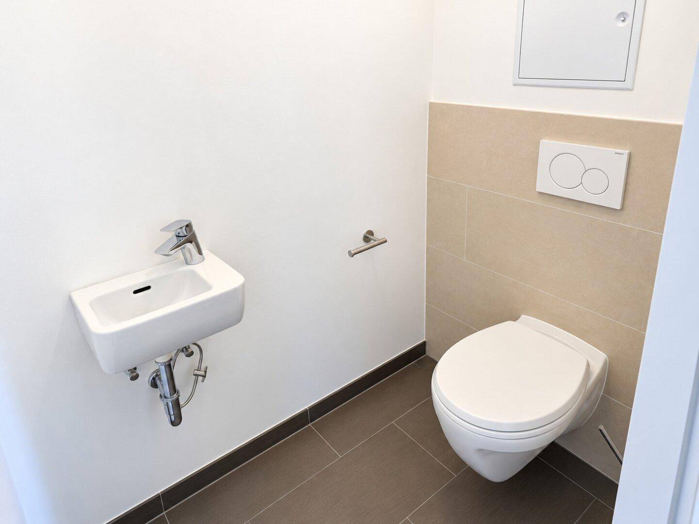 Kleines Gäste-WC mit wandhängender Toilette und kompaktem Waschbecken.