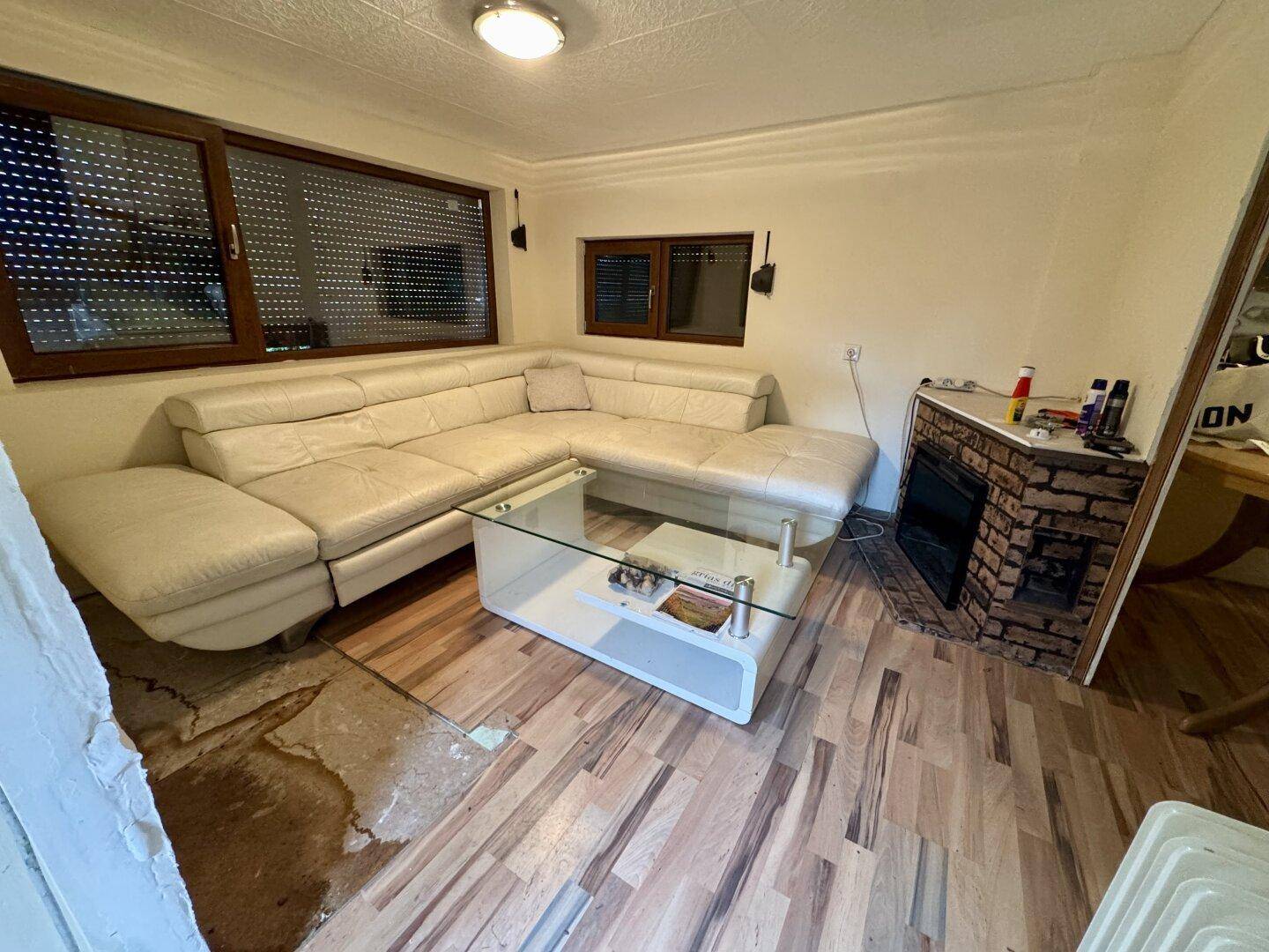 Gemütliches Wohnzimmer mit hellem Ecksofa und modernem Couchtisch, bereit zum Entspannen.