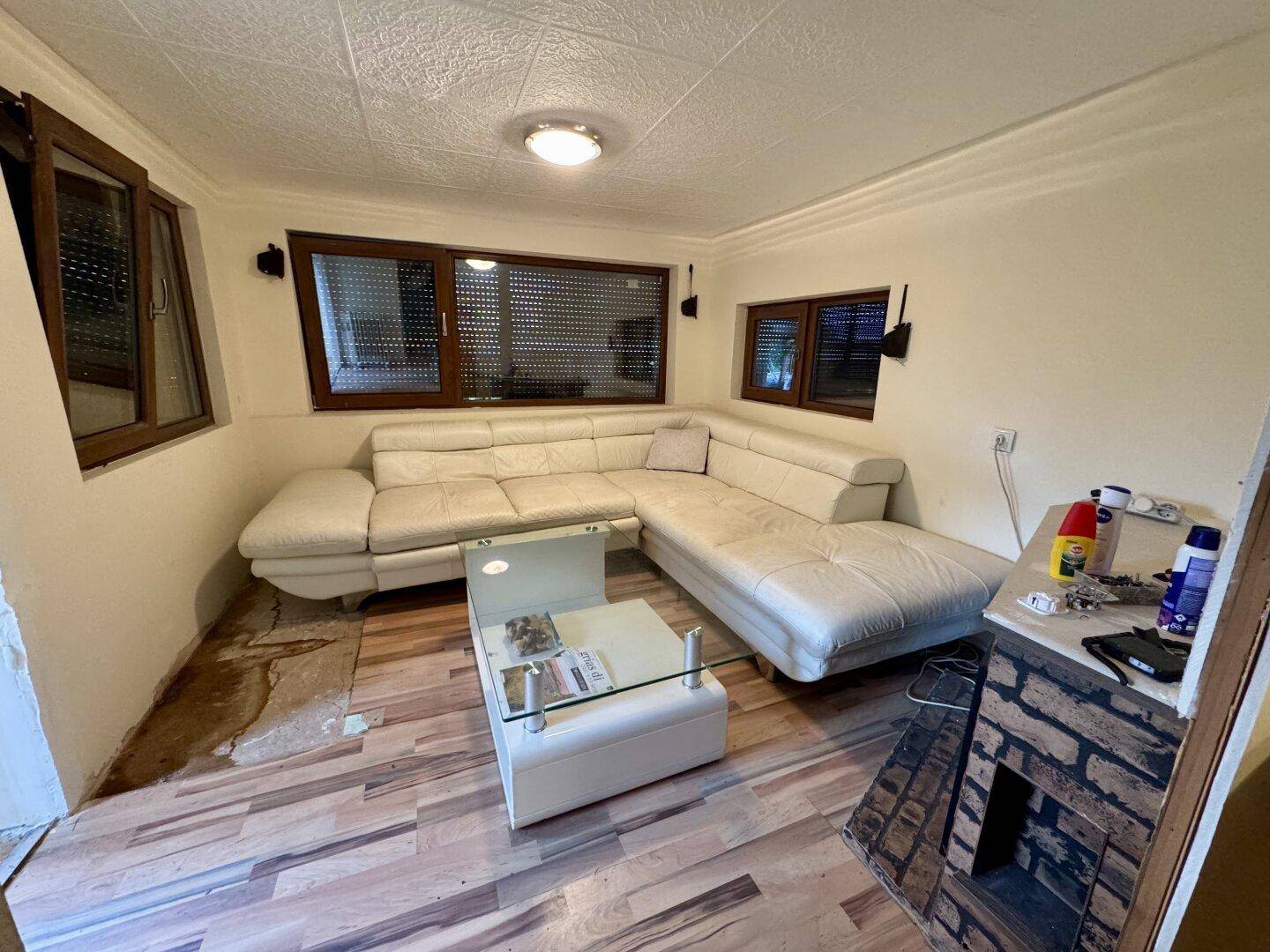 Wohnzimmer mit großem Ecksofa, Couchtisch und einem dekorativen Kamin.