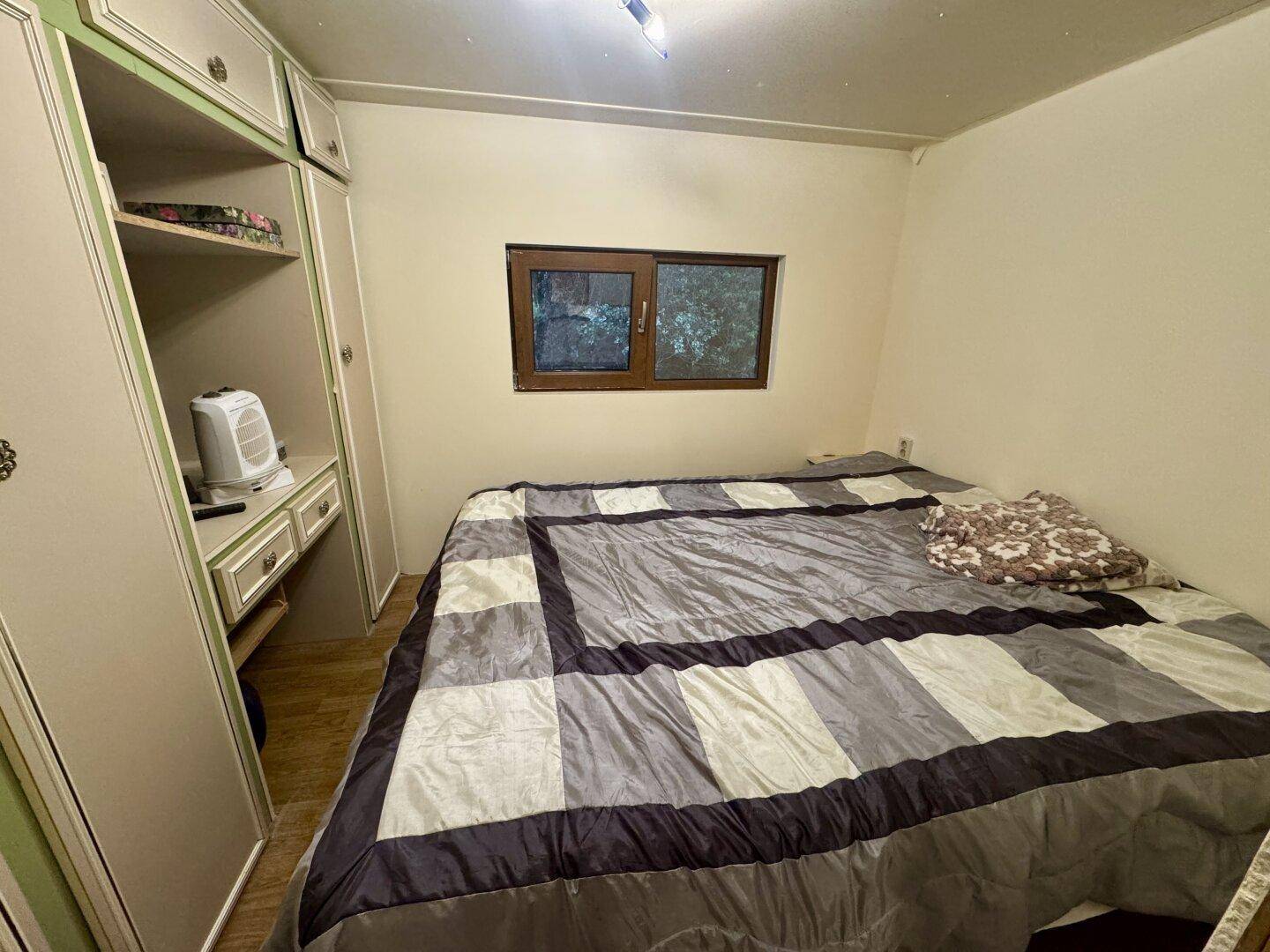 Schlafzimmer mit Doppelbett und integriertem Kleiderschrank, bietet viel Stauraum.