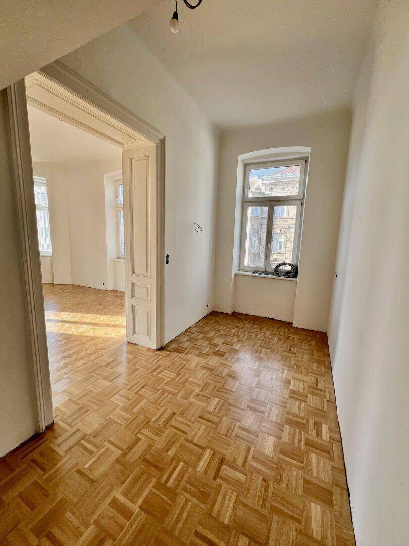 Kleineres Zimmer mit Parkettboden und einem Fenster, ideal als Arbeits- oder Gästezimmer.