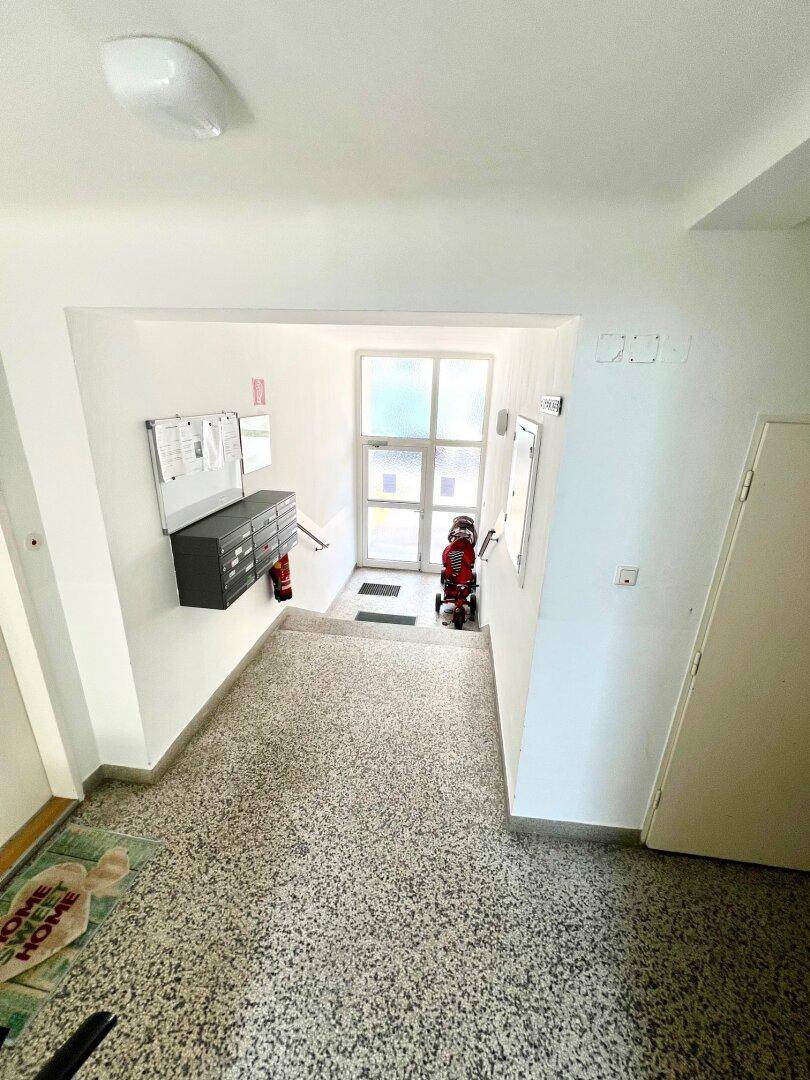 Eingangsbereich eines Mehrfamilienhauses mit Briefkästen und Zugang zum Treppenhaus.