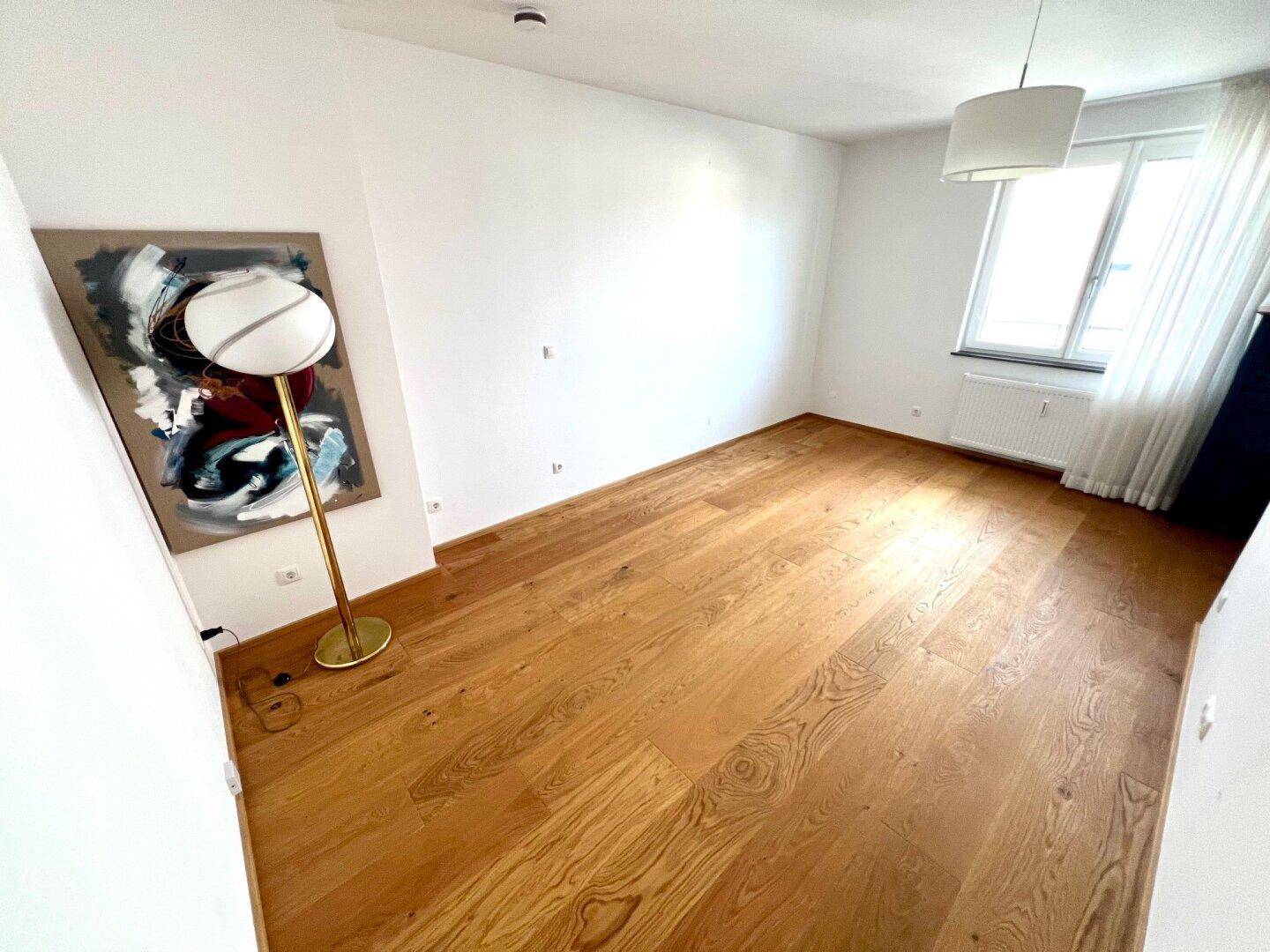 Geräumiges Zimmer mit Eichenparkett und viel Tageslicht, bereit zur individuellen Gestaltung.