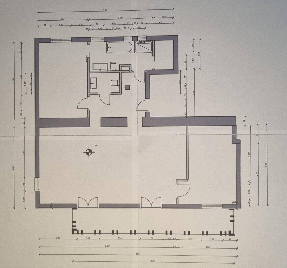 Grundriss einer Wohnung mit Bad, WC und offenem Wohnbereich.