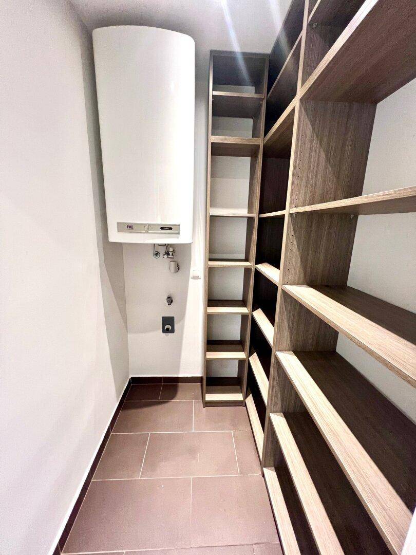 Praktischer Abstellraum mit Regalsystem und Warmwasserboiler, bietet zusätzlichen Stauraum.