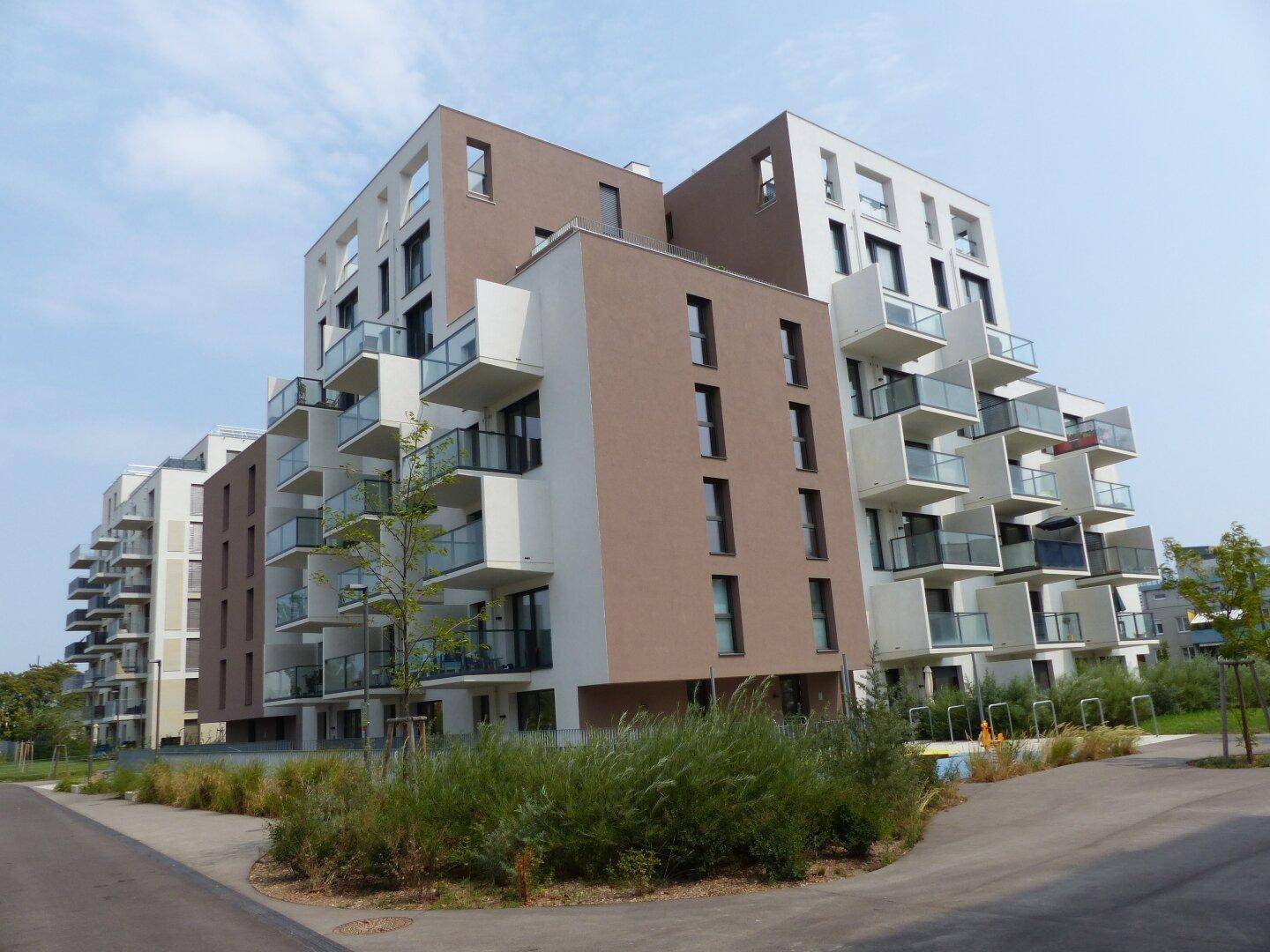 Moderne Wohnanlage mit mehreren Gebäuden, Balkonen und ansprechender Architektur.