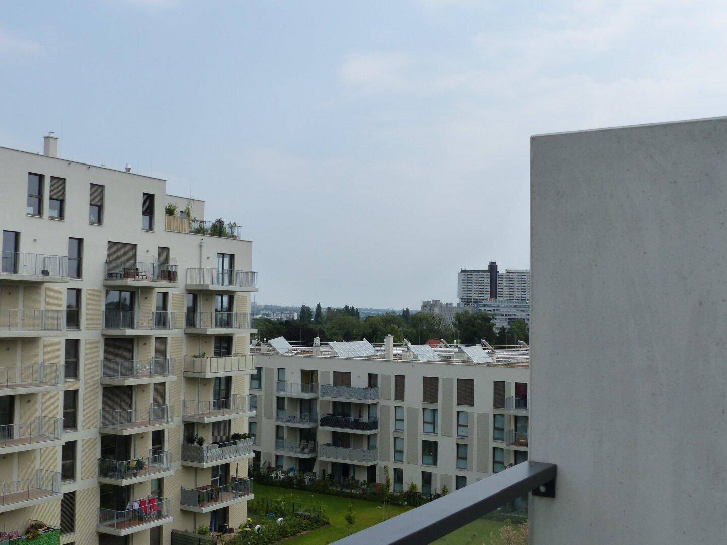 Weitblick von einem Balkon über moderne Wohngebäude und die städtische Umgebung.