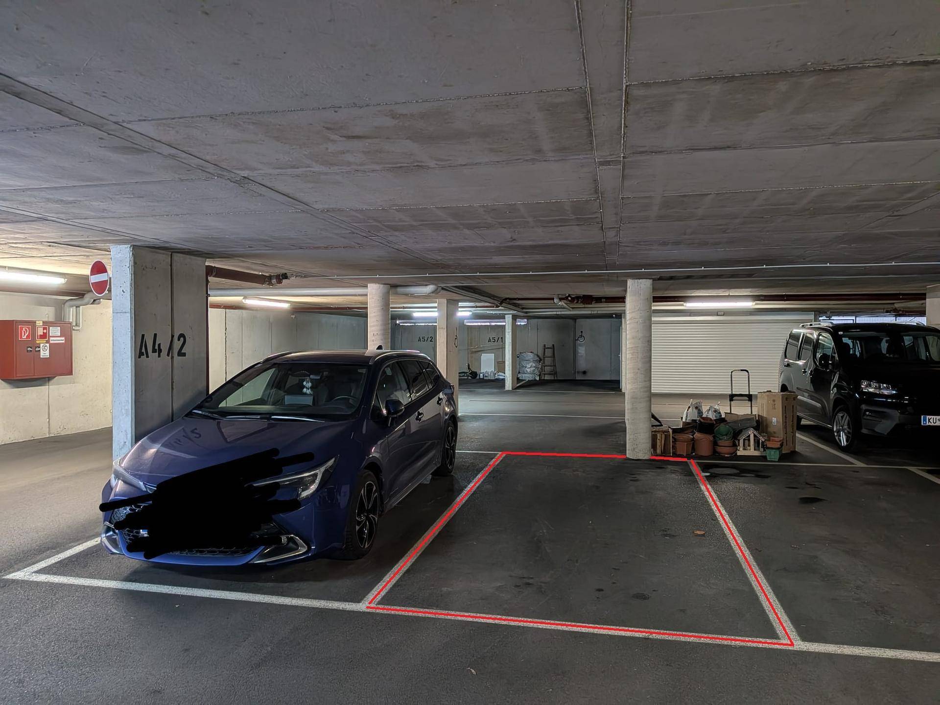 Geräumige Tiefgarage mit einem markierten Parkplatz und Betonwänden.