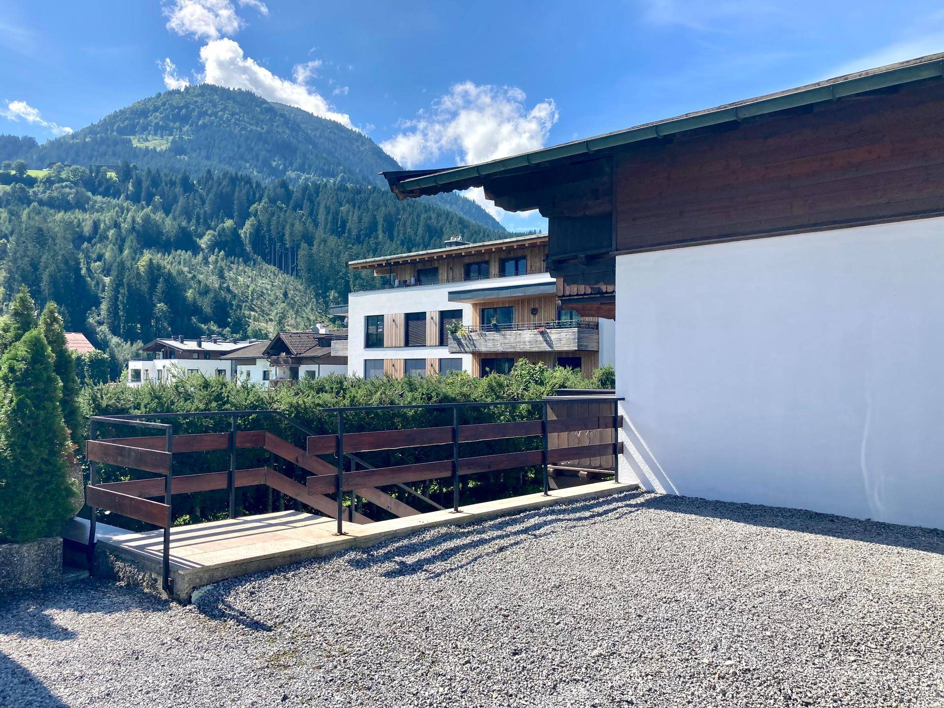 Außenansicht des Anwesens mit Schotterfläche und beeindruckendem Bergblick im Hintergrund.