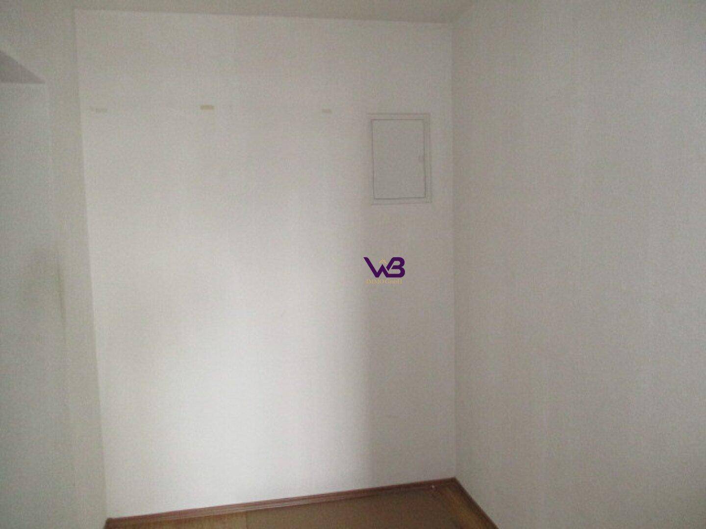 Leerer Raum mit weißen Wänden und einem kleinen Wartungszugang.