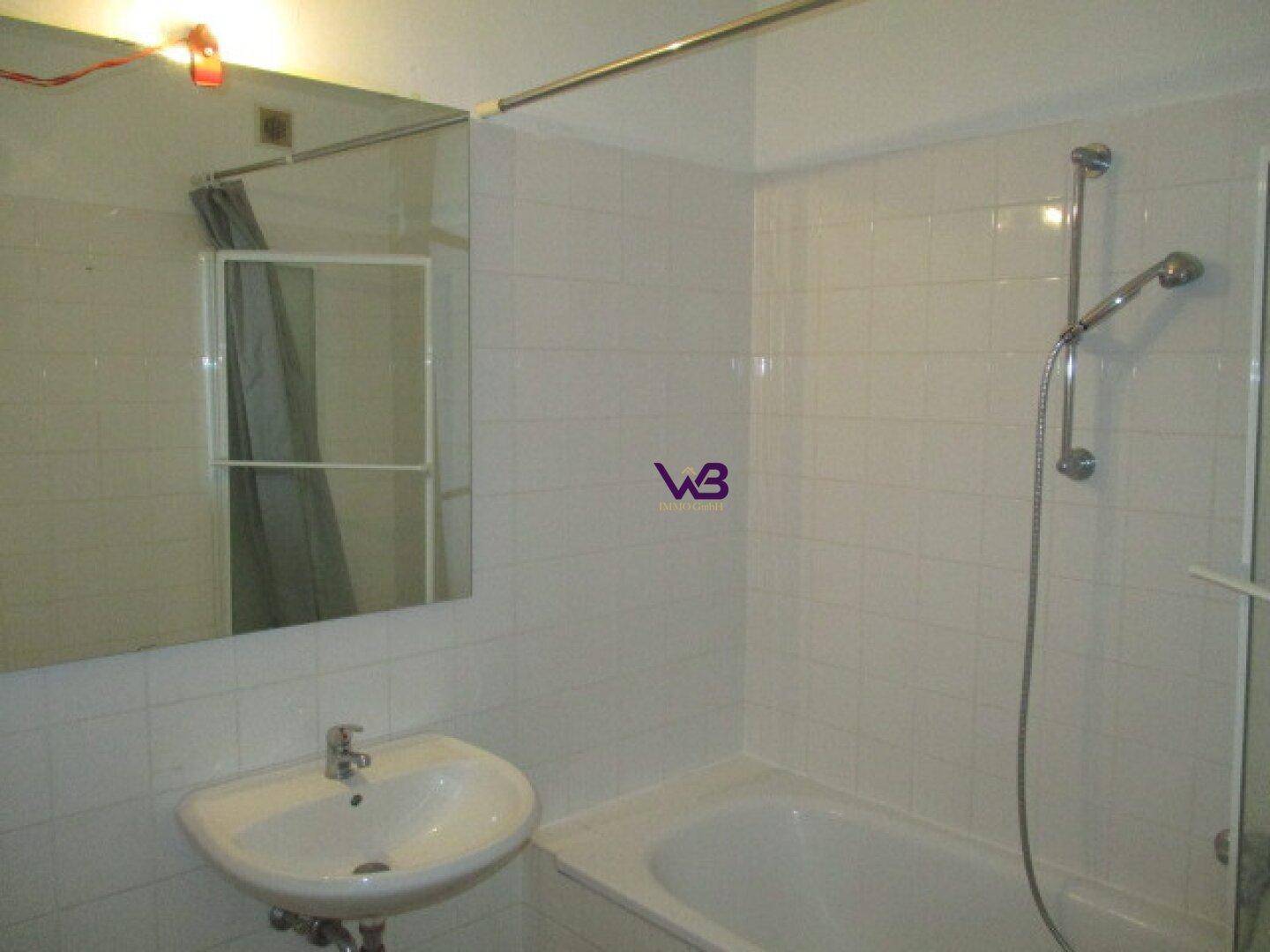 Helles Badezimmer mit Badewanne, Duschkopf und Waschbecken.