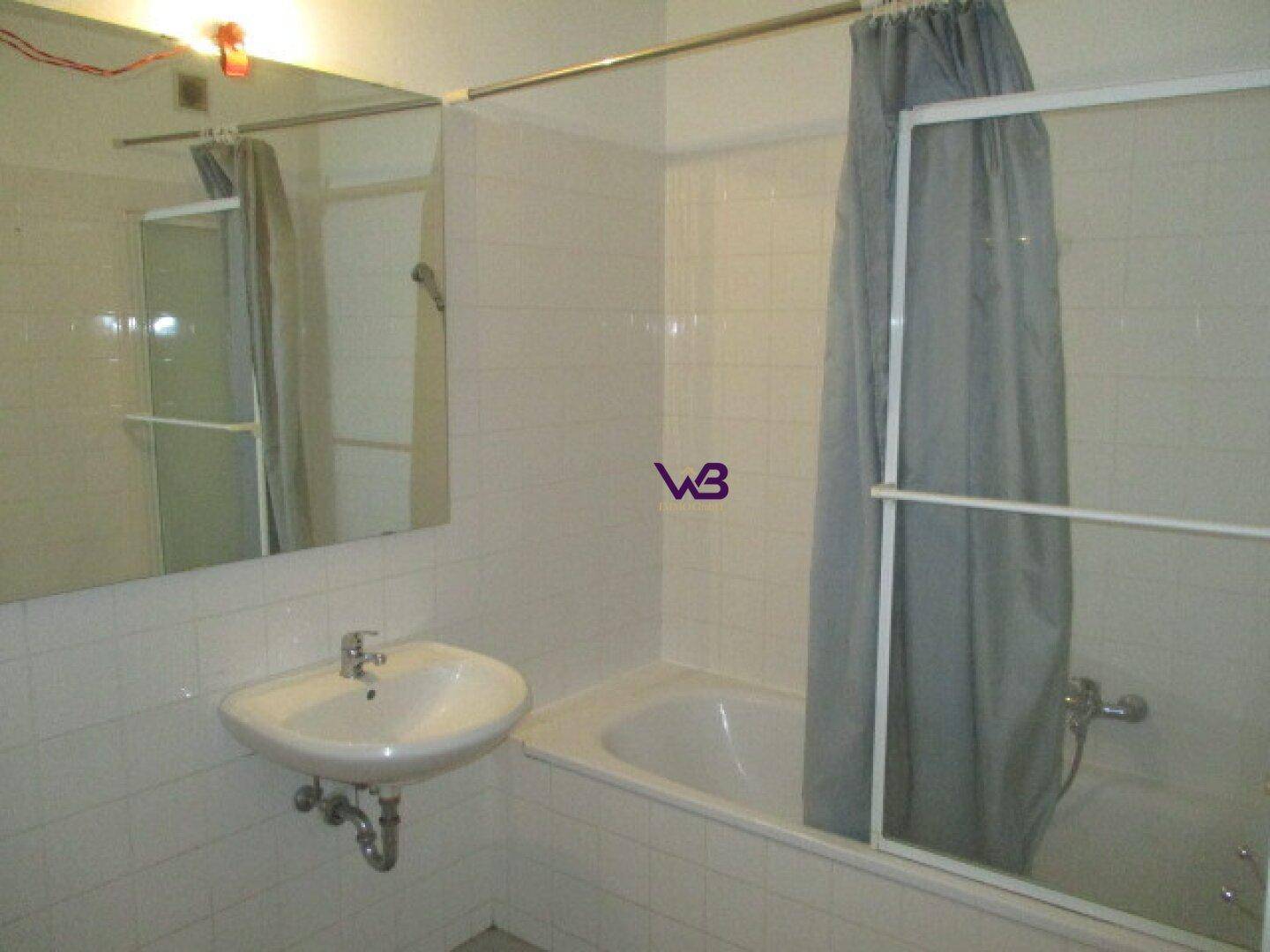 Badezimmer mit Badewanne, Duschvorhang, Waschbecken und weiß gefliesten Wänden.