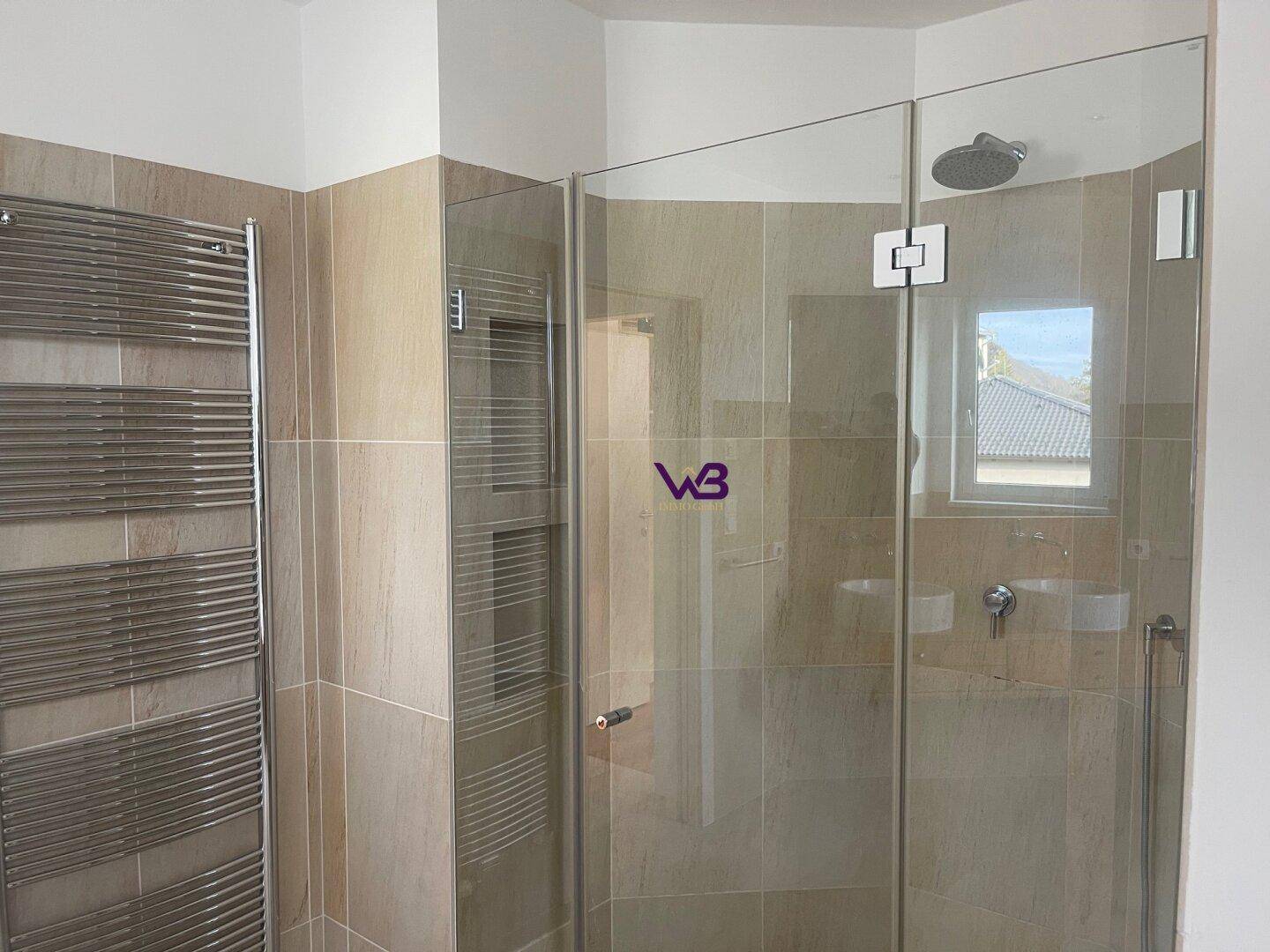 Badezimmer mit begehbarer Dusche, Regendusche und beheiztem Handtuchhalter.