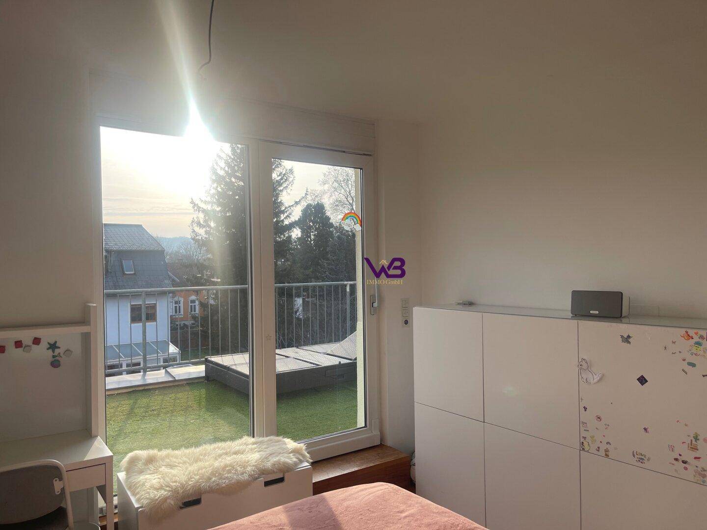Helles Schlafzimmer mit Kleiderschrank und großen Fenstern zum Außenbereich.